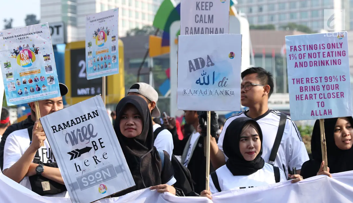 Sejumlah remaja mengangkat tulisan menyambut datangnya bulan Ramadan saat acara Car Free Day di Kawasan Bundaran Hotel Indonesia, Jakarta, Minggu (13/5). Mereka mengajak warga untuk menyambut bulan suci bagi umat muslim. (Liputan6.com/Helmi Fithriansyah)