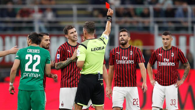 Wasit Piero Giacomelli memberikan kartu merah kepada pemain AC Milan Mateo Musacchio saat menghadapi Fiorentina dalam Serie A di Stadion San Siro, Milan, Italia, Minggu ( 29/9/2019). AC Milan kalah 1-3 saat menjamu Fiorentina. (AP Photo/Antonio Calanni)