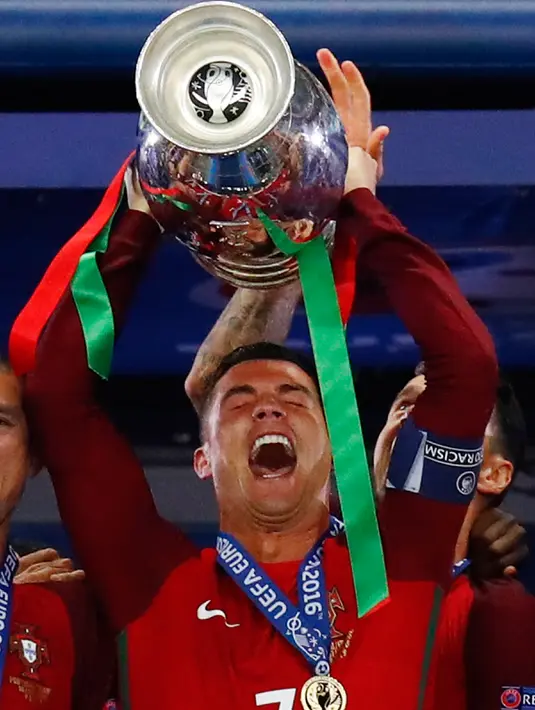 Cristiano Ronaldo mengangkat tropi Piala Eropa 2016 usai memenangkan laga melawan Prancis di Stade de France, Senin (11/7). Ronaldo menorehkan sejumlah prestasi di ajang bergengsi tersebut. (REUTERS)