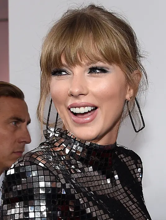 Penyanyi Taylor Swift menghadiri ajang American Music Awards 2018 di Microsoft Theater, Los Angeles, Selasa (9/10). Taylor Swift menata rambutnya dengan up-do simple yang memperlihatkan anting dari Ofira Jewels. (Kevork Djansezian/Getty Images/AFP)