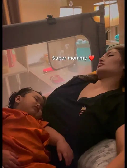 Sibad tampak tidur ala kadarnya demi sang buah hati yang sedang sakit. Sedangkan putrinya masih tetap di pangkuannya juga tertidur lelap. [Instagram/krisjianabah]