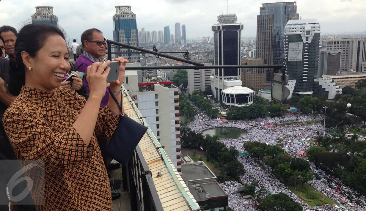Menteri BUMN, Rini Soemarno mengabadikan gambar demo 2 Desember di atas gedung BUMN, Jakarta, Rabu (2/12). Demo 2 Desember digelar sebagai lanjutan dari aksi 4 November 2016. (Liputan6.com/Ferbian Pradolo)