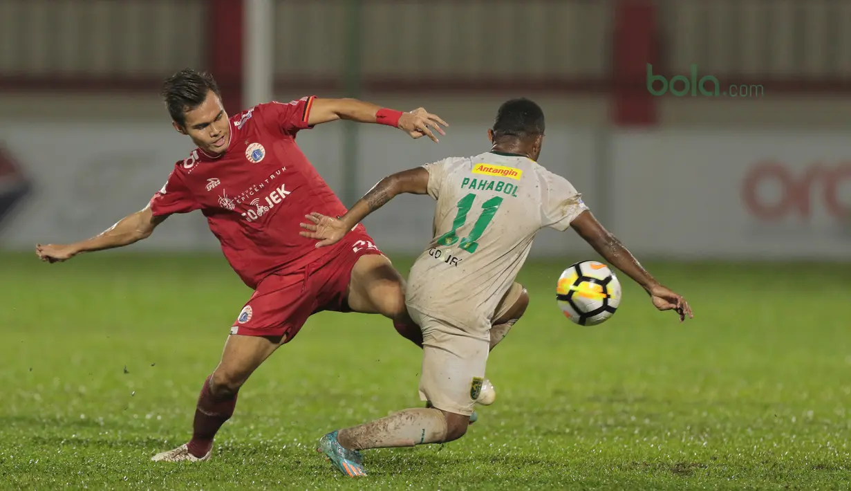 Pemain Persija Jakarta, Rezaldi Hehanussa (kiri) berebut bola dengan pemain Persebaya Surabaya, Pahabol pada laga Gojek Liag 1 bersama Bukalapak di Stadion PTIK, Jakarta (26/6/2018). Persija dan Persebaya bermain imbang 1-1. (Bola.com/Nick Hanoatubun)