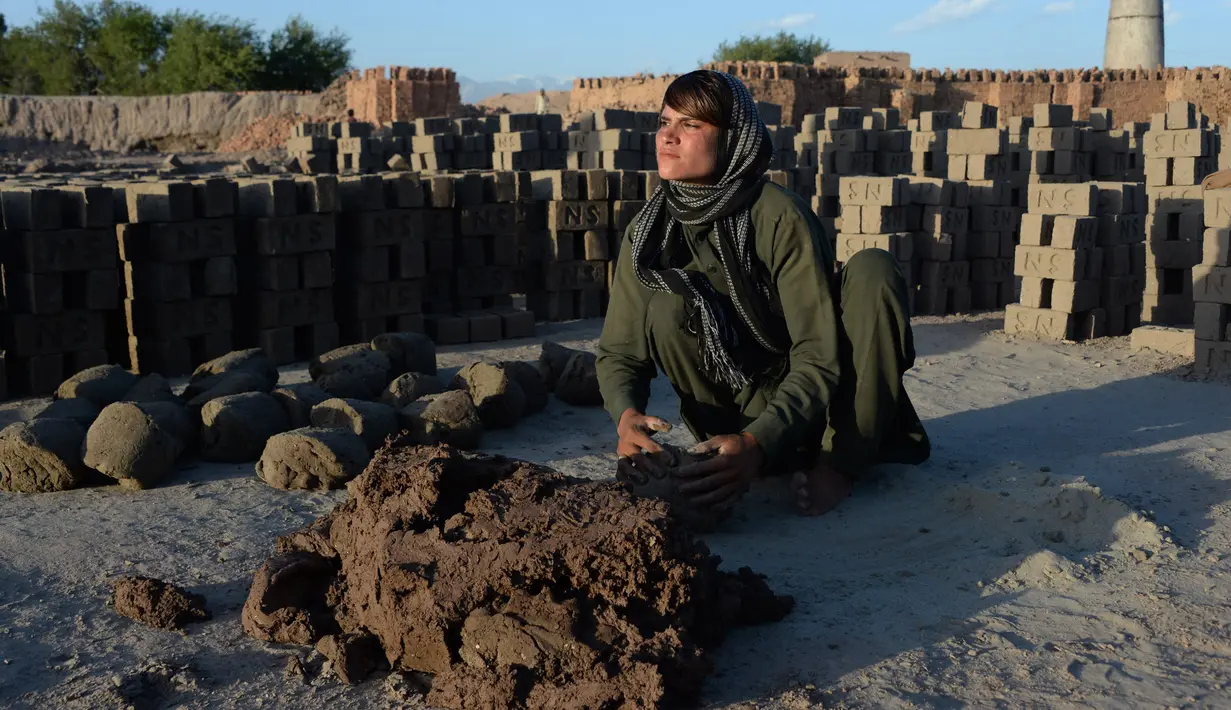 Perempuan Afghanistan, Sitara Wafadar menyamar sebagai laki-laki saat bekerja di pabrik batu bata, Provinsi Nangarhar, 27 Maret 2018. Dengan lima saudari, Sitara hidup sebagai laki-laki yang di wilayah setempat disebut bacha poshi (NOORULLAH SHIRZADA/AFP)