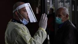 Seorang pekerja medis memberikan instruksi kepada orang-orang yang menunggu vaksin COVID-19 di aula olahraga di ibu kota Sarajevo, Bosnia, Rabu (21/4/2021). Bosnia telah melaporkan lebih dari 7.000 kematian COVID-19 dari 3,3 juta populasinya - di antara angka terburuk di Eropa. (AP Photo/Eldar Emri