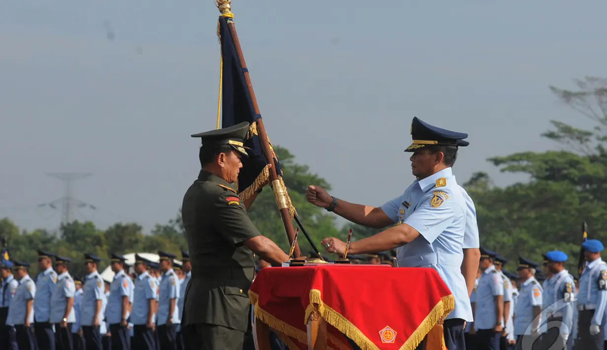 Panglima TNI Jenderal TNI Moeldoko (kiri) menyerahkan pataka TNI AU kepada Marsekal Madya TNI Agus Supriatna saat upacara serah terima jabatan KASAU di Lanud Halim Perdanakusuma,  Jakarta, Kamis (15/1/2015). (Liputan6.com/Herman Zakharia)