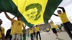 Suporter membentangkan gambar legenda sepak bola Brasil, Pele, jelang menyaksikan laga Kamerun vs Brasil di Stadion Nasional Brasil, (23/6/2014). (REUTERS/Ueslei Marcelino)
