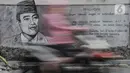 Pengendara melintasi mural bergambar sosok Presiden Soekarno di Jalan Pluit Raya III, Jakarta, Senin (10/8/2020). Mural itu diharapkan menjadi media agar masyarakat selalu mengingat sejarah dan menghargai jasa para pahlawan dalam memerdekakan Tanah Air. (merdeka.com/Iqbal Nugroho)