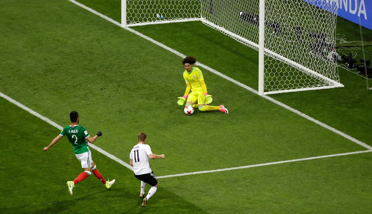 Kiper Meksiko,  Guillermo Ochoa berusaha menghalau bola tendangan penyerang Jerman, Timo Werner saat bertanding di semifinal Piala Konfederasi 2017 di Stadion Fisht, Sochi, Rusia, (29/6). Jerman menang 4-1 atas Meksiko. (AP Photo/Sergei Grits)