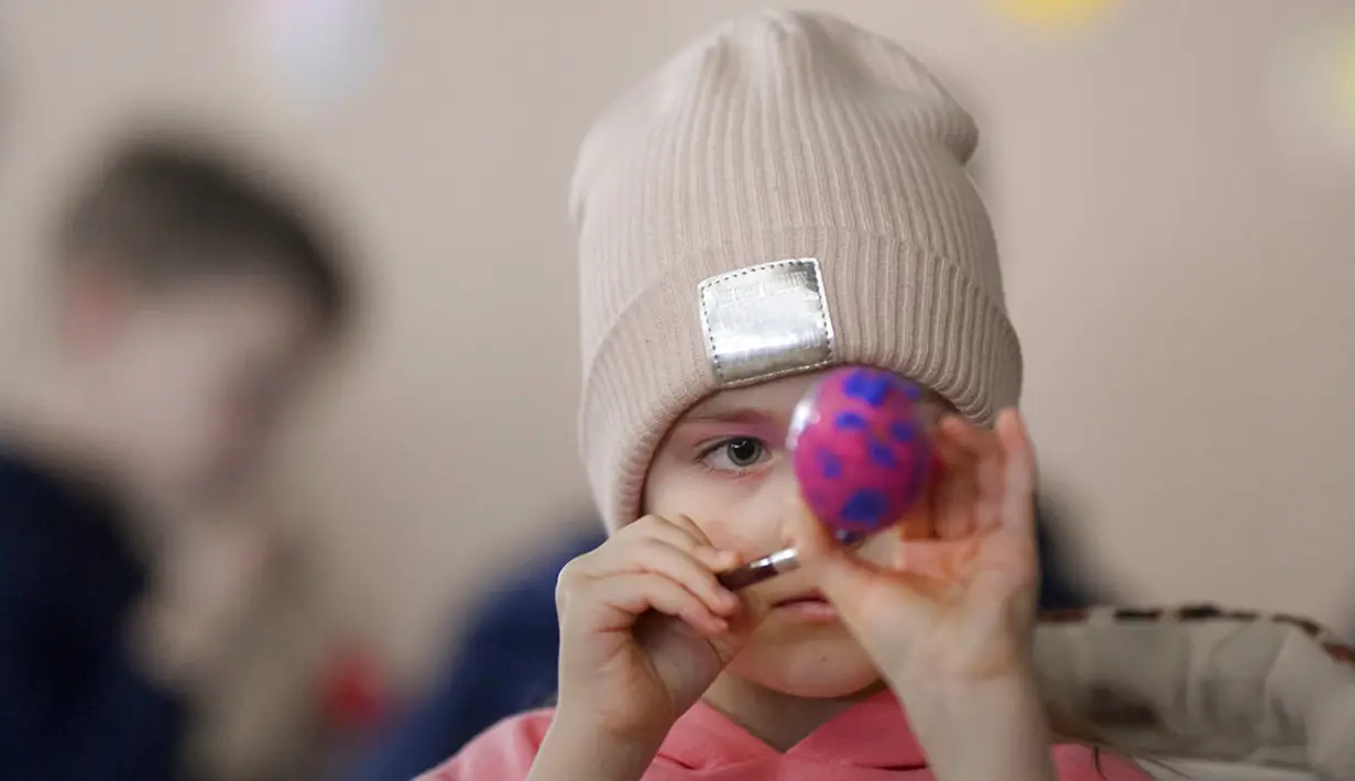 <p>Pengungsi anak-anak Ukraina melukis telur Paskah pada Kamis Putih di sebuah pusat pengungsi di Bucharest, Rumania, 21 April 2022. Orang Rumania yang mayoritas jemaat Ortodoks merayakan Minggu Paskah pada 24 April. (AP Photo/Andreea Alexandru)</p>