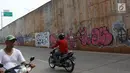 Pengendara sepeda motor melintas di sekitar dinding Jalan Tol Depok-Antasari (Desari), Ciganjur, Jakarta Selatan, Rabu (24/10). Aksi vandalisme menyebabkan dinding tol tampak kumuh dan tidak terawat. (Liputan6.com/Immanuel Antonius)