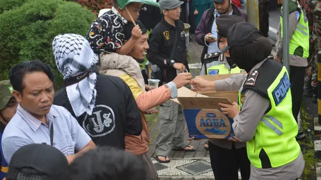 Polwan cantik membagikan air mineral dan permen untuk peserta aksi bela Palestina di Wonosobo. (Foto: Liputan6.com/Muhamad Ridlo/Polres Wonosobo).