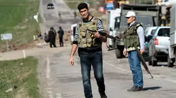 Petugas keamanan berjaga disekitaran terjadinya serangan bom remote kontrol di Diyarbakir, Turki (18/2). Bom tersebut menghantam kendaraan lapis baja milik militer Turki. (REUTERS / Sertac kayar)