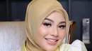 Aurelie Hermansyah tampil dengan nuansa makeup yang natural. Lipstik, perona pipi, dan eye makeup bernuansa kecokelatan menyempurnakan outfit kuning dan jilbab cokelat mudanya. Foto: Instagram.