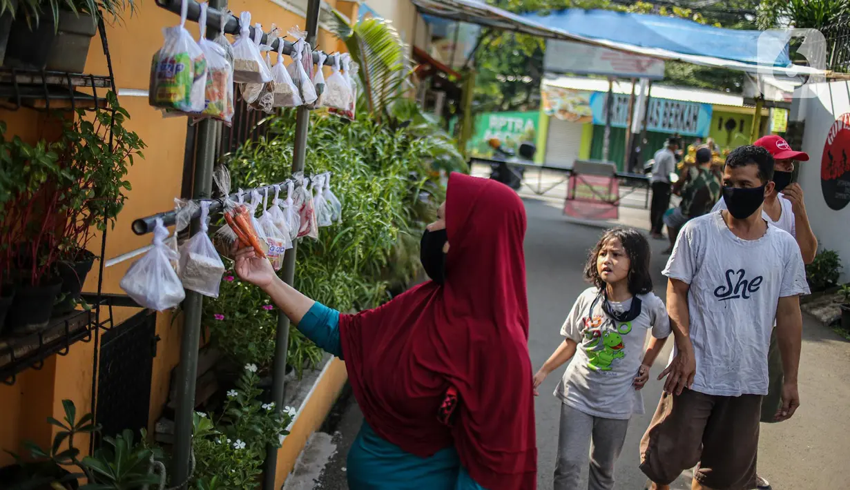 Warga memilih sayur mayur hasil sumbangan di RT 02 RW 04, Kelurahan Jati Padang, Jakarta, Jumat (22/5/2020). Pakaian bekas layak pakai serta sayur mayur disediakan bagi warga terdampak Pembatasan Sosial Berskala Besar (PSBB) untuk pencegahan COVID-19. (Liputan6.com/Faizal Fanani)