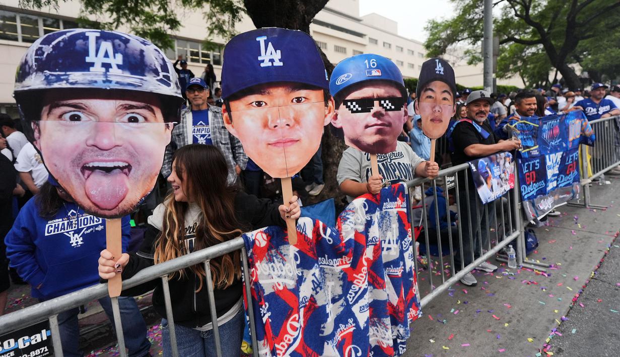 Sejumlah fans memakai topeng Shohei Ohtani dkk saat menanti pawai tim Los Angeles Dodgers setelah menjuarai 2025 World Series Championship di Los Angeles, California, Senin (03/11/2025) waktu setempat. (AP Photo/Jae C. Hong)