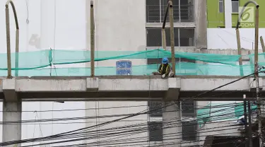 Pekerja menyelesaikan pembangunan JPO Pasar Rumput di Jakarta, Selasa (15/1). Pembangunan jembatan di bangunan pasar yang terintegrasi dengan rusun tersebut dibuat untuk memudahkan mobilitas warga. (Liputan6.com/Immanuel Antonius)