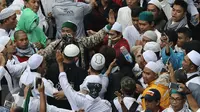 Sekelompok orang saat mengintimidasi hingga memukul para jurnalis yang tengah meliput aksi 112 di Masjid Istiqlal, Jakarta Pusat. (Liputan6.com/Herman Zakharia)