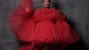 Lizzo tampil dramatis dalam balutan gaun tulle strapless crimson dengan lengan mengembang, rok tutu pendek yang dijepit di pinggang, dan long train.  Bintang pop itu menata gaun Giambattista Valli kustom itu dengan tumit sandal bertali merah yang serasi dan aksesori sederhana dengan anting-anting mutiara. (Instagram/lizzo).