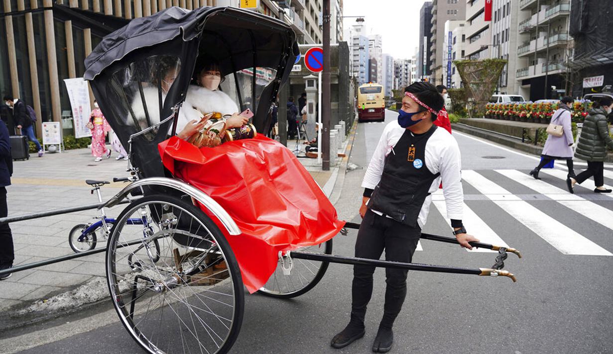 Para wanita berusia 20 tahun yang mengenakan kimono naik becak untuk mengikuti upacara Coming of Age Day di Tokyo, Jepang, Senin (10/1/2022). Coming of Age Day diadakan setiap tahun pada Senin kedua bulan Januari untuk merayakan remaja Jepang menjadi dewasa. (AP Photo/Eugene Hoshiko)