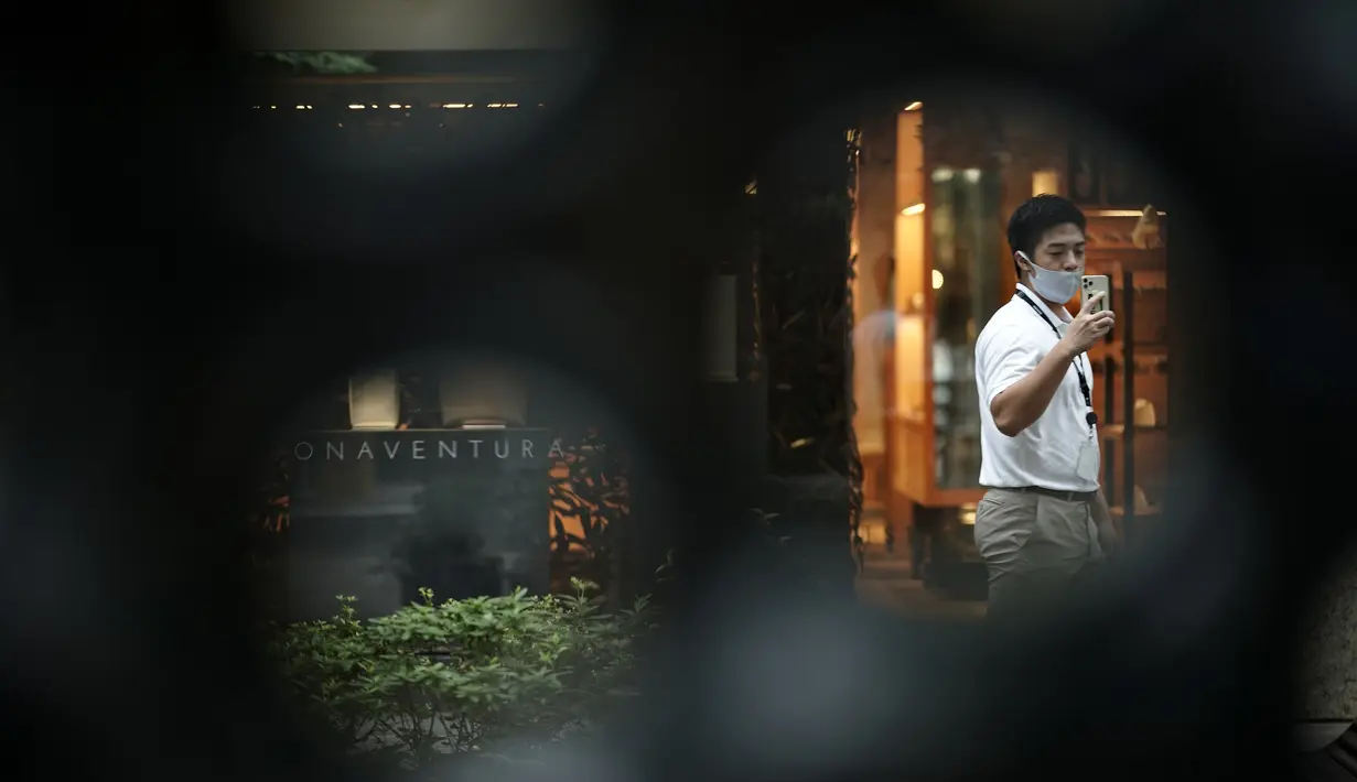 Seorang pria yang mengenakan masker untuk membantu mencegah penyebaran virus corona berjalan melalui pusat kota Tokyo, Kamis (10/9/2020). Ibu kota Jepang itu mengonfirmasi lebih dari 270 kasus virus corona pada Kamis. (AP Photo / Eugene Hoshiko)