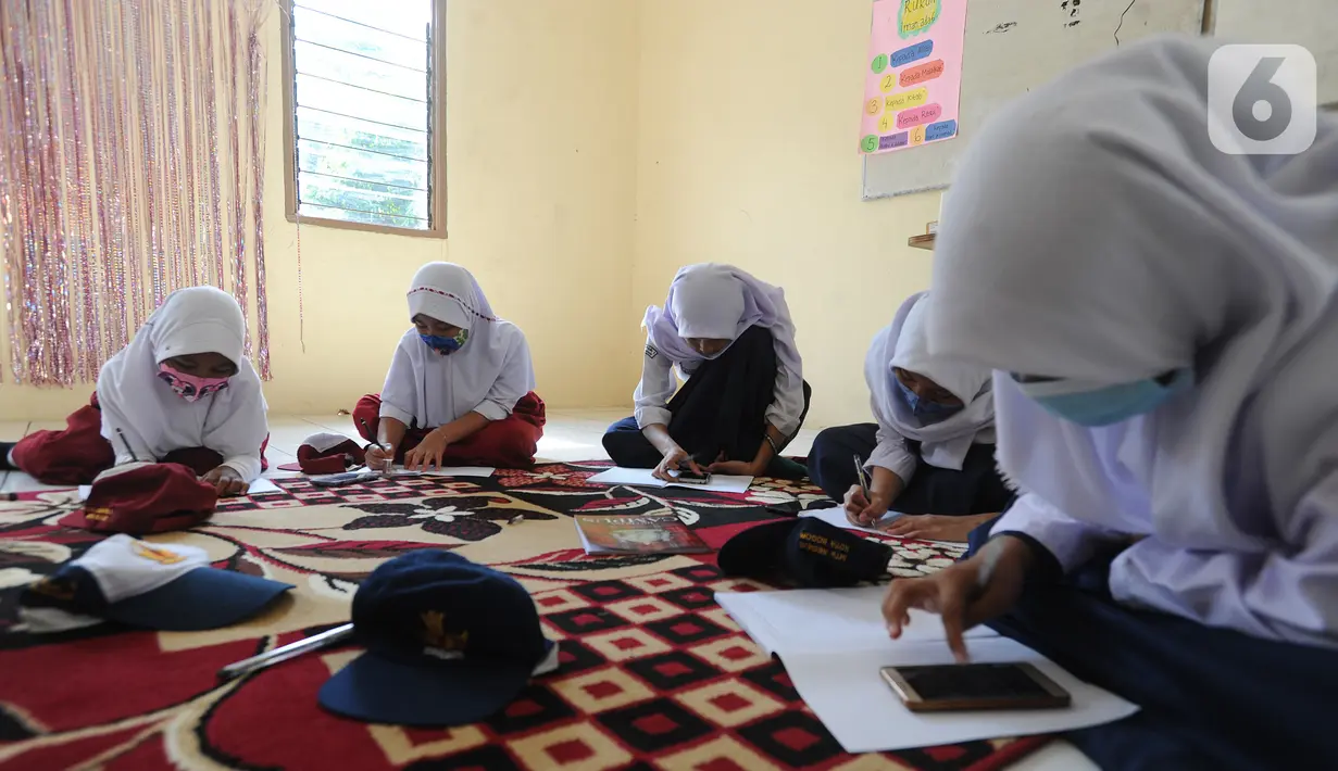 Murid-murid SD dan SMP belajar dengan memanfaatkan wifi gratis di Balai RW kawasan Tegal Gundil, Bogor, Jawa Barat, Senin (21/9/2020). Pemkot Bogor menyebar lebih dari 50 titik wifi publik gratis untuk menunjang Pembelajaran Jarak Jauh (PJJ) siswa di Kota Bogor. (merdeka.com/Arie Basuki)