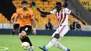 Pemain Olympiakos, Mady Camara berebut bola dengan gelandang Wolverhampton Wanderers, Ruben Neves pada leg kedua babak 16 besar Liga Europa di Molineux Stadium, Kamis (6/8/2020). Wolverhampton menumbangkan Olympiakos dengan skor 1-0. (AP Photo/Rui Vieira)