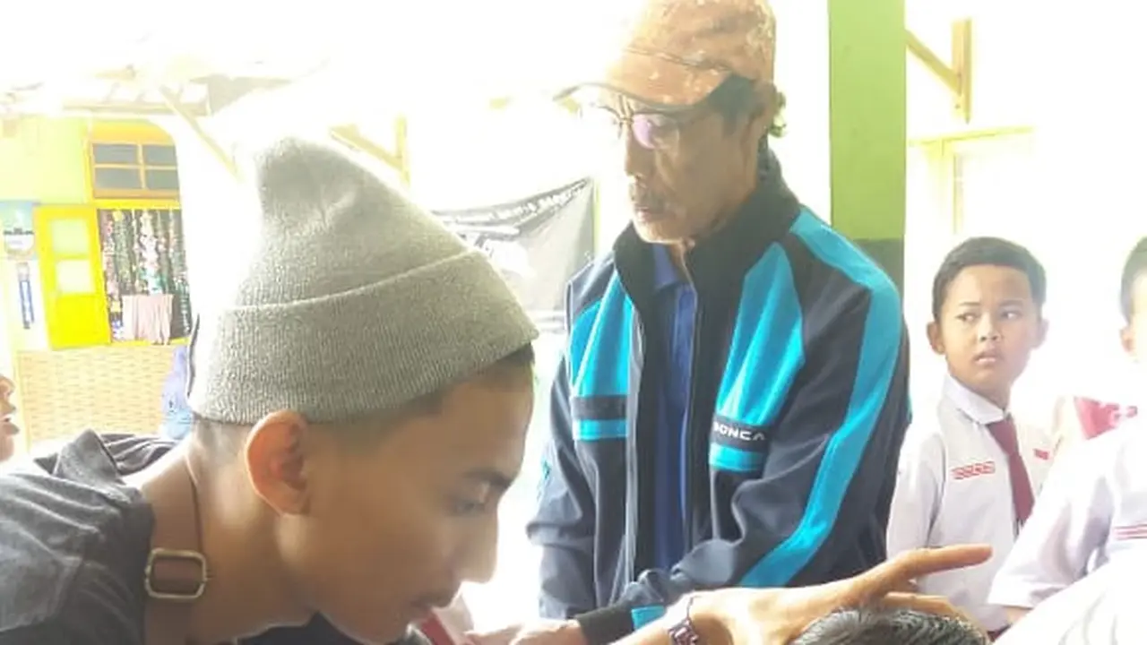 Para siswa SDN 1 Bayongbong, Garut nampak asik saat pelaksanaan cukur rambut gratis saat Hari Anak Sedunia