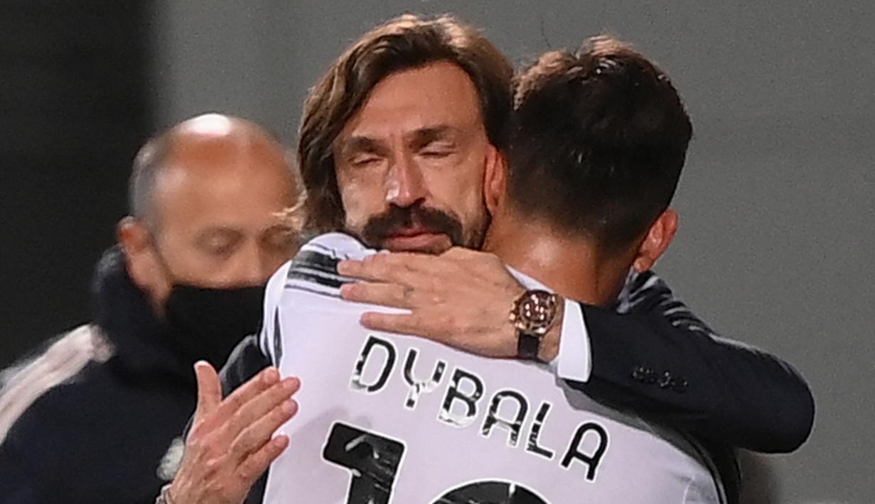 Manajer tim Juventus, Andrea Pirlo memeluk striker Paulo Dybala usai ditarik keluar dalam laga lanjutan Liga Italia 2020/2021 pekan ke-36 di Mapei-Citta del Tricolore Stadium, Rabu (12/5/2021). Juventus menang 3-1 atas Sassuolo. (AFP/Marco Bertorello)