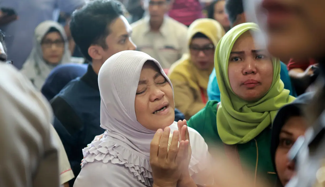Keluarga korban jatuhnya pesawat Lion Air JT-610 rute Jakarta-Pangkalpinang berdoa saat berada di Bandara Pangkalpinang, Bangka Belitung, Senin (29/10). Mereka menanti kabar kondisi anggota keluarganya dari pihak maskapai dan pemerintah. (AP Photo)