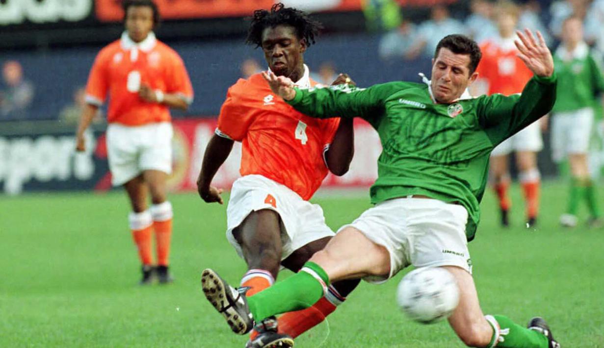 Gelandang Timnas belanda, Clarence Seedorf (kiri) berebut bola dengan bek Republik Irlandia, Liam O'Brien pada laga persahabatan di Rotterdam (4/6/1996). Clarence Seedorf mencetak satu gol dalam laga debutnya bersama Timnas Belanda saat menang 5-0 atas Luksemburg pada ajang kualifikasi Euro 1996 (14/12/1994). Pemain yang pensiun pada Januari 2014 ini total mengoleksi 87 caps dengan raihan 11 gol dan 7 assist. (AFP/ANP/Mulder/Antonisse)