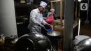 Ketua KPK, Firli Bahuri menunjukkan keahliannya memasak nasi goreng untuk dibagikan kepada para pimpinan KPK dan Dewan Pengawas saat acara silaturahmi di Jakarta, Senin (20/1/2020). Firli yang biasanya mengenakan jas dan kemeja, kini mengenakan celemek dan topi koki. (merdeka.com/Dwi Narwoko)