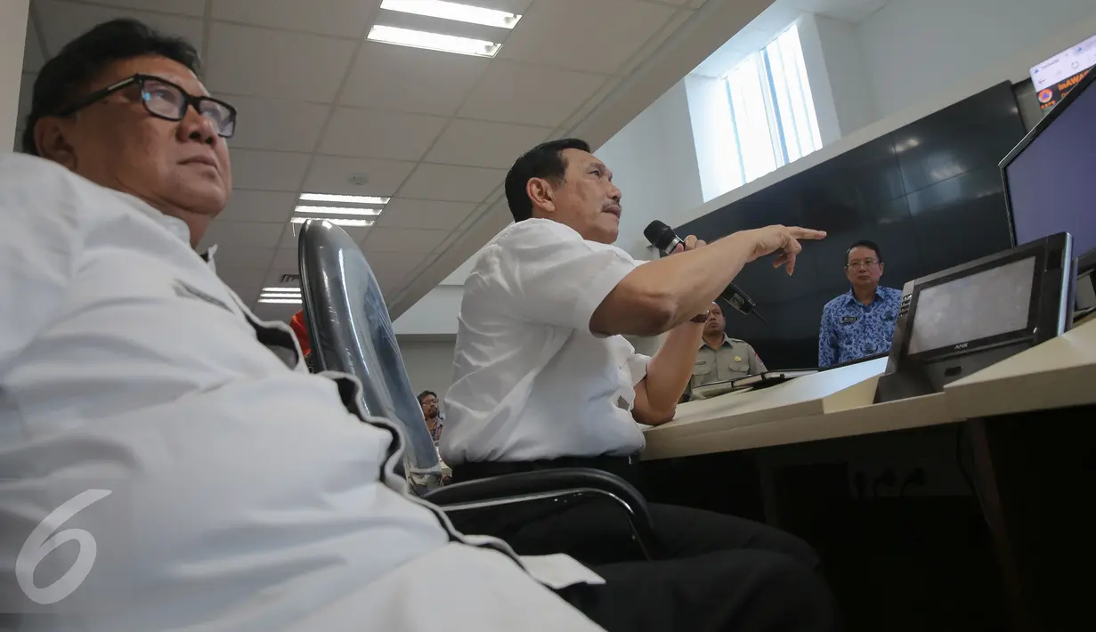 Mendagri Tjahjo Kumolo (kiri) dan Menkopolkuham Luhut B Panjaitan saat memimpin video conference dengan pejabat Riau dan Palembang terkait penanganan bencana asap di Graha BNPB, Jakarta, Rabu (28/10). (Liputan6.com/Faizal Fanani)