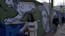 Orang-orang yang memakai masker berjalan di pelabuhan Piraeus, dekat Athena, Senin (13/12/2021). Yunani meningkatkan kampanye vaksinasi menjelang liburan Natal saat negara itu bergulat dengan lonjakan infeksi yang membawa angka kematian COVID-19 mendekati rekor. (AP/Thanassis Stavrakis)