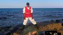 Petugas menepikan mayat yang terapung di pantai di Kota Pesisir Tajoura, Libya, Minggu (4/12). Diduga orang yang tenggelam itu akan meninggalkan Libya karena berharap dapat menjadi imigran di negara lain. (REUTERS / Hani Amara)