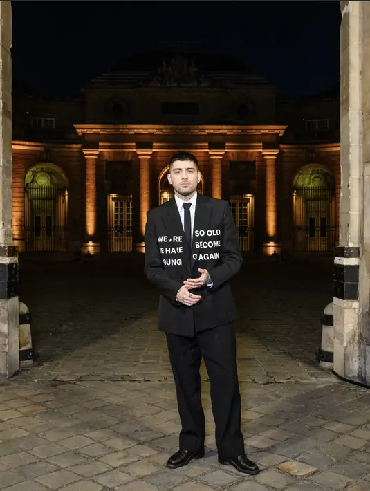 Zayn Malik tampil luar biasa dengan jas yang dilengkapi dengan typography penuh pesan. Ia hadirkan jas dan kemeja nuansa warna basic. [Foto: Valentino]