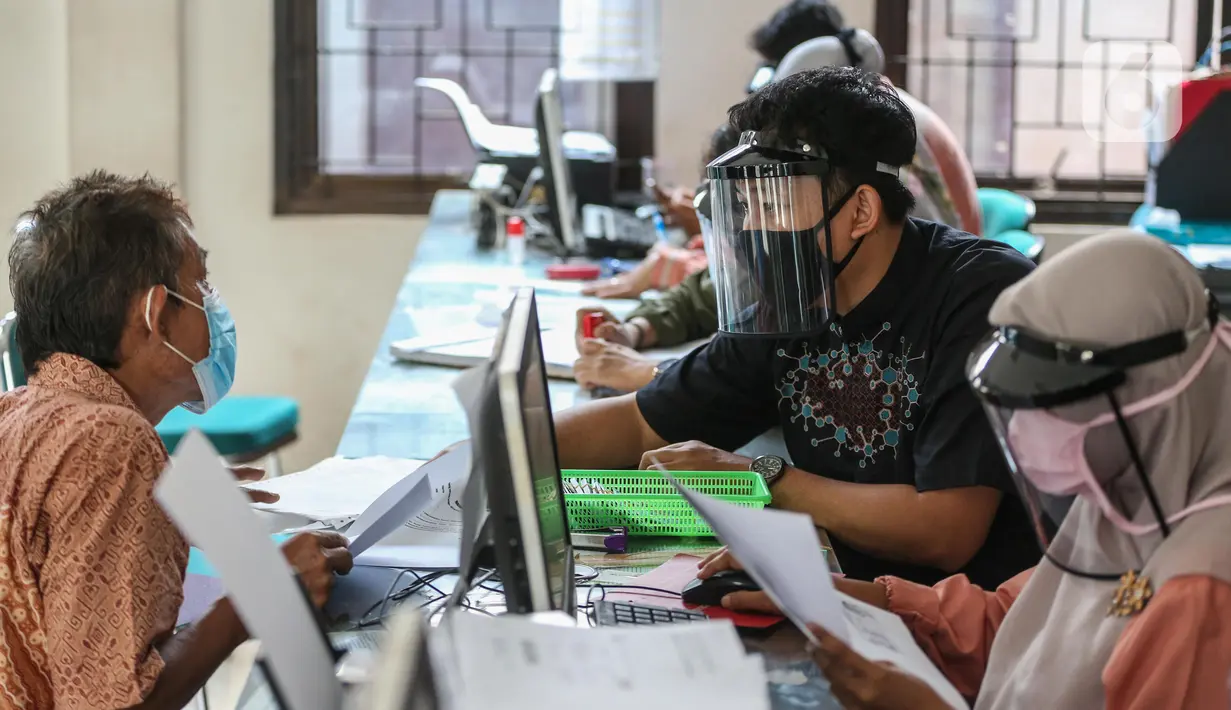 Petugas menggunakan face shield saat melayani masyarakat Dinas Kependudukan Kecamatan Pamulang, Tangerang Selatan, Jumat (29/5/2020).  Penggunaan Face Shield tersebut sebagai salah satu upaya untuk melindungi diri dalam penyebaran COVID-19. (Liputan6.com/Faizal Fanani)