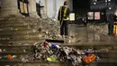 Seorang pekerja membersihkan sampah dari tangga di pusat kota London, setelah Italia mengalahkan Inggris dalam perebutan gelar juara EURO 2020, pada Minggu (11/7/2021). Usai pertandingan, jalan-jalan di London juga dipenuhi sampah. (AP Photo/Matt Dunham)