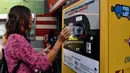 Seorang calon penumpang menukarkan sampah botol plastik dengan tiket kereta menggunakan mesin daur ulang di stasiun metro bawah tanah Cipro, Roma, Selasa (8/10/2019). (Photo by Tiziana FABI / AFP)