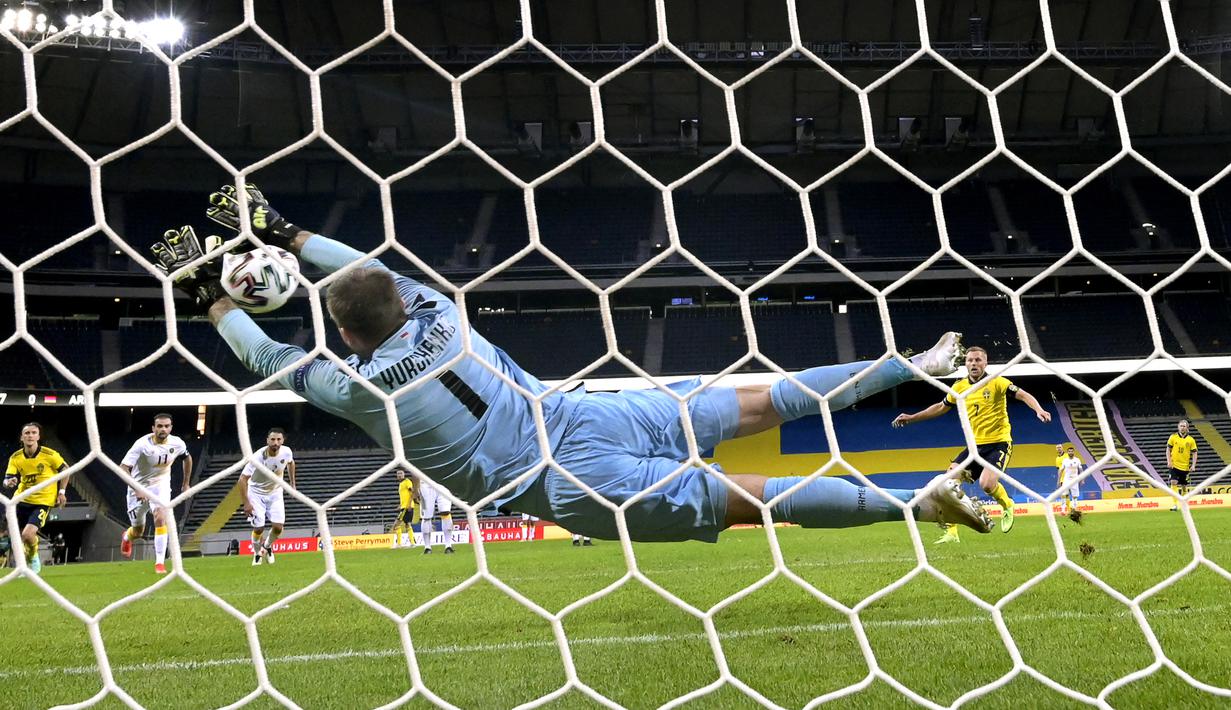 Kiper Armenia, David Yurchenko berhasil menggagalkan eksekusi penalti galeandang Swedia, Sebastian Larsson dalam laga uji coba menjelang berlangsungnya Euro 2020 di Solna, Sabtu (5/6/2021). Armenia kalah 1-3 dari Swedia. (AFP/Jonathan Nackstrand)