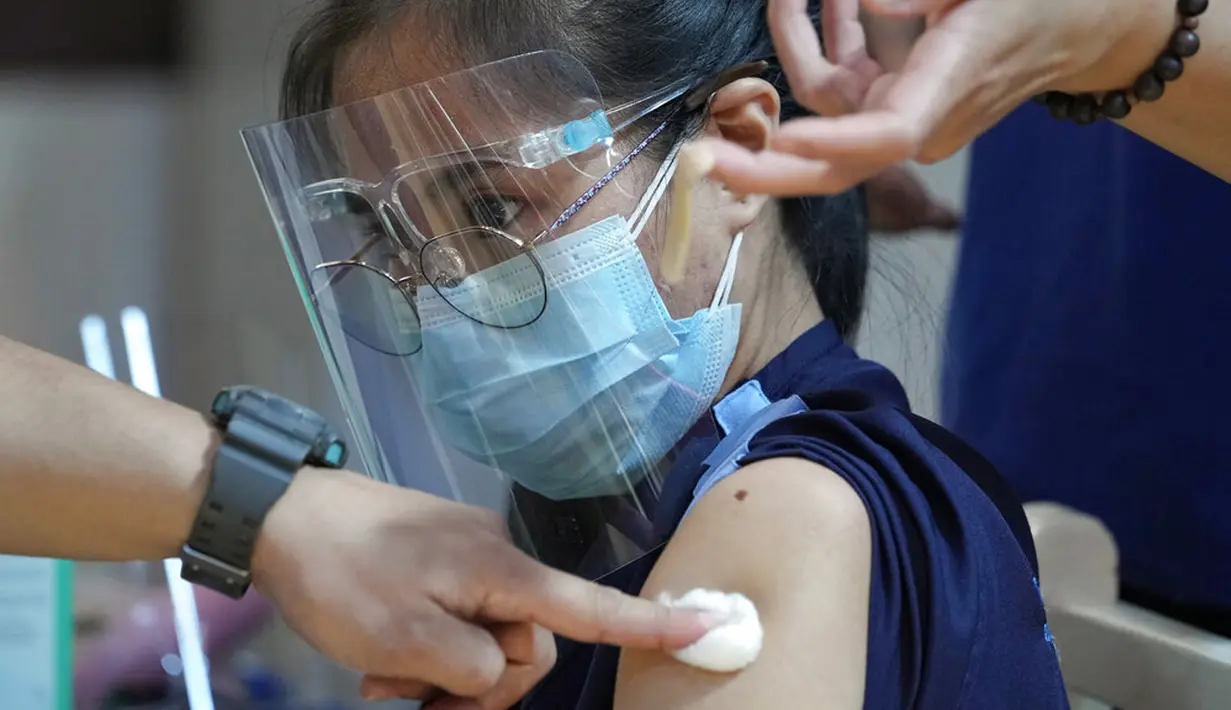 Seorang petugas kesehatan disuntik dengan vaksin COVID-19 Pfizer di National Kidney and Transplant Institute, Quezon City, Filipina, 17 November 2021. Pemerintah Filipina mulai menyuntikkan booster vaksin COVID-19 kepada pekerja garis depan. (AP Photo/Aaron Favila)