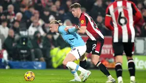Nathan Collins membayangi Erling Haaland dalam laga Premier League antara Brentford vs Manchester City, Rabu (15/1/2025). (c) AP Photo/Alastair Grant