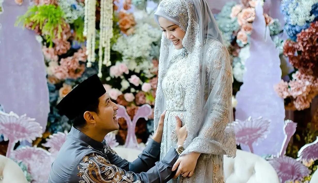 Sentuhan motif floral pada gaunnya memberikan kesan feminin yang lembut, sementara siluetnya yang sederhana tetap mencerminkan kenyamanan sebagai ibu hamil. Gaun ini dilengkapi dengan hijab senada yang membuat penampilannya semakin anggun dan bersahaja, serasi dengan tema acara yang intim dan penuh kebahagiaan. [@chand_kelvin].