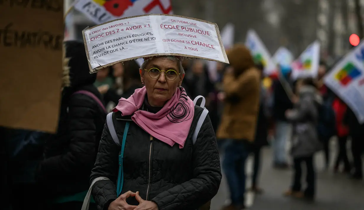 Seorang demonstran ikut serta dalam aksi unjuk rasa setelah seruan pemogokan dan protes oleh serikat guru terkait gaji dan kondisi kerja, di Lyon, Prancis, pada 1 Februari 2024. (JEFF PACHOUD/AFP)