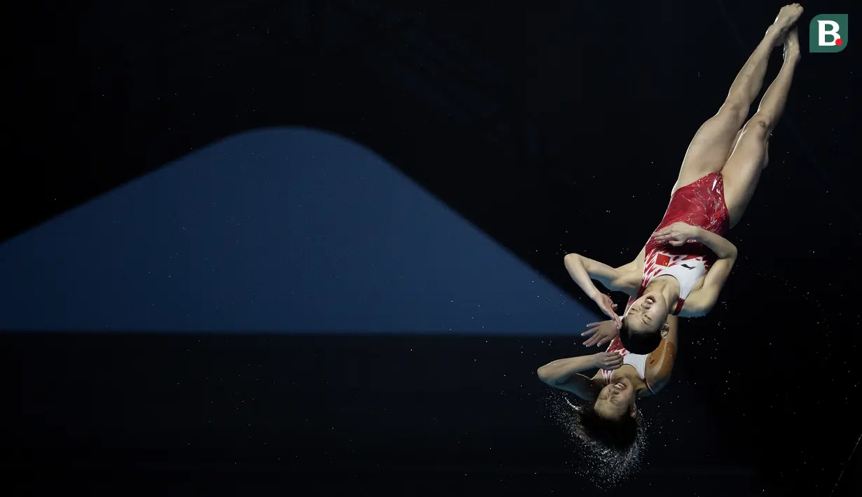 Aksi Zhang Jiaqie dan Zhang Minjie pasangan peloncat indah asal China yang meraih medali emas di nomor papan 10 meter sinkronisasi pada Asian Games 2018 di Stadion Akuatik, Gelora Bung Karno Senayan Jakarta, Selasa (28/8/2018). (Bola.com/Peksi Cahyo)