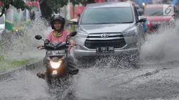 Pengendara bermotor melewati banjir di Jalan Cinere Raya (depan Mall Cinere), Depok, Jawa Barat, Minggu (31/3). Banjir terjadi akibat sistem drainase yang buruk. (merdeka.com/Arie Basuki)