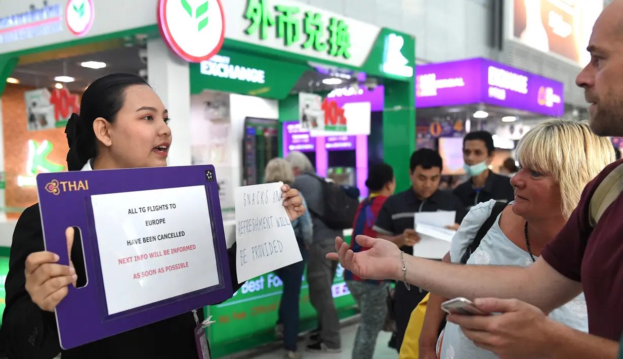 Staf Thai Airways berbicara dengan penumpang di Bandara Internasional Suvarnabhumi di Bangkok (28/2). Pembatalan penerbangan tersebut karena konflik yang memanas antara India dan Pakistan di perbatasan Kashmir. (AFP Photo/Lillian Suwnrumpha)
