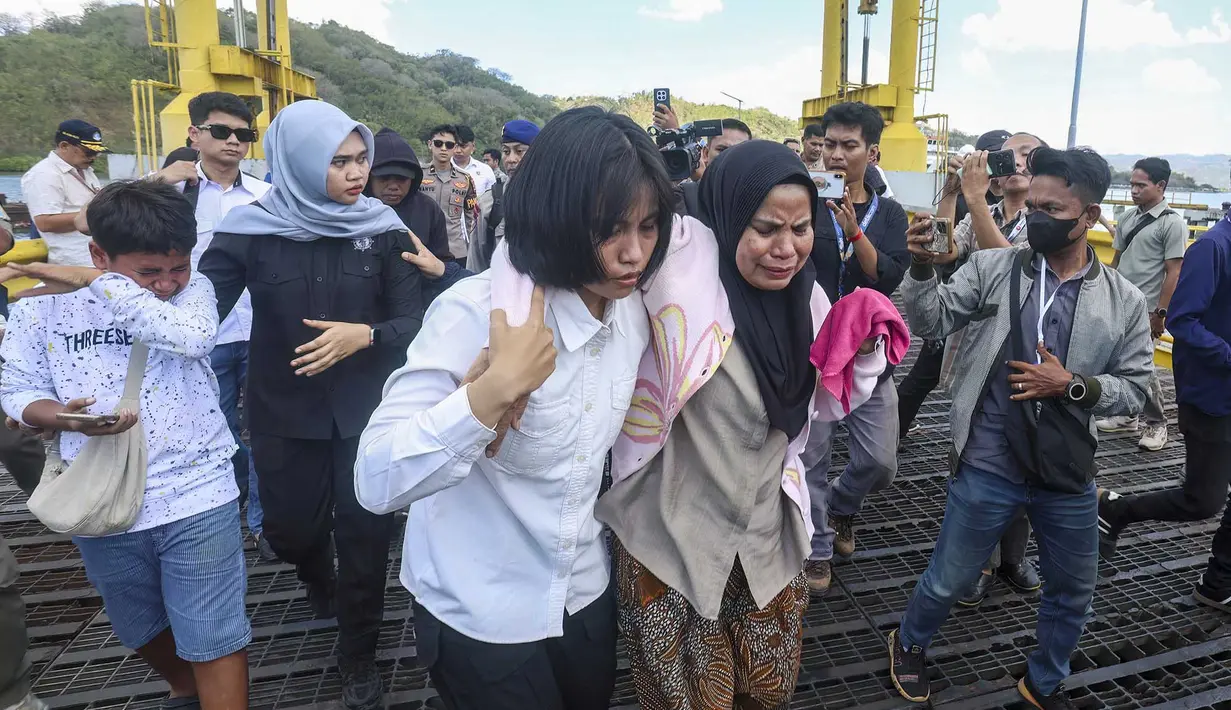 Petugas SAR membantu seorang wanita  turun dari kapal pencarian dan penyelamatan di Pelabuhan Lembar, Lombok Barat, Rabu, 12 Agustus 2026. (AFP)