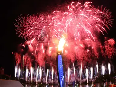 Pesta kembang api yang menjadi latar kaldron api SEA Games menghiasi langit Singapura pada saat Pembukaan SEA Games 2015 di Stadion Nasional Singapura. Jumat (5/6). (Bola.com/Arief Bagus)