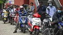 Pengendara motor mengantre di sepanjang jalan untuk membeli bahan bakar dari stasiun bahan bakar Lanka IOC di Kolombo, Selasa (24/5/2022). Sri Lanka yang kekurangan uang menaikkan harga bahan bakar secara tajam ke rekor tertinggi pada 24 Mei 2022, menyebabkan penderitaan lebih lanjut bagi 22 juta orang di negara itu dalam krisis terburuk sejak kemerdekaan. (Ishara S. KODIKARA / AFP)